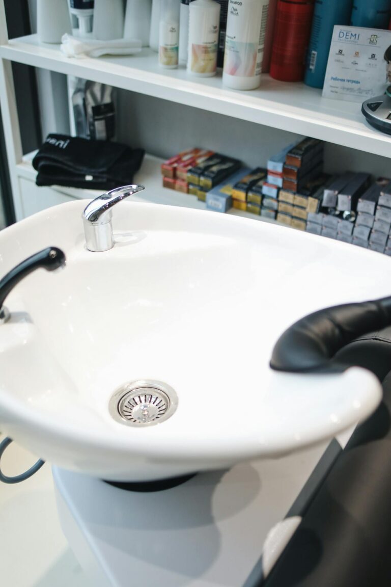A stylish hair salon shampoo station with products on shelves.